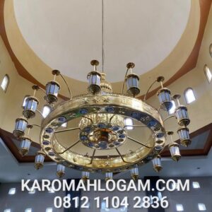 Lampu gantung Nabawi kuningan sedang dipasang di dalam masjid oleh tim Karomah Logam